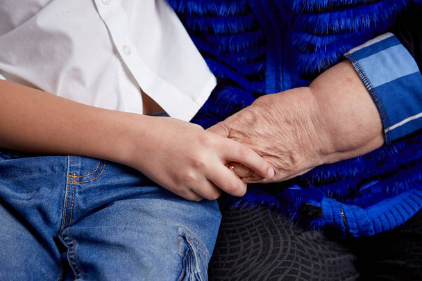 Wnuk i babcia trzymają się za ręce. Spędzamy razem czas. Rodzinny czas. Wysokiej jakości zdjęcie - Zdjęcie, obraz