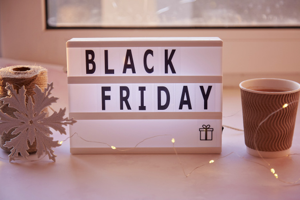 Signboard with text Black Friday, cardboard cup with cocoa. Online shopping concept. Cozy home. High quality photo - Foto, Imagem