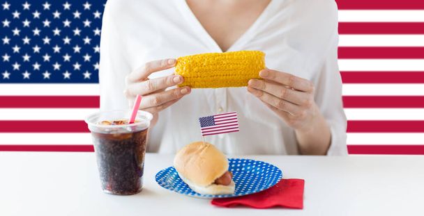 woman eating corn at independence day party - Фото, изображение