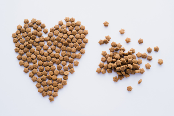 vista superior de alimentos secos para mascotas en forma de corazón aislado en blanco - Foto, Imagen