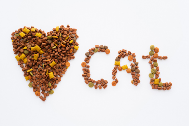 top view of heart and cat lettering made of dry pet food isolated on white - Fotografie, Obrázek