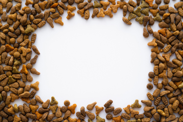 vue de dessus du cadre en aliments croquants pour animaux isolés sur blanc - Photo, image