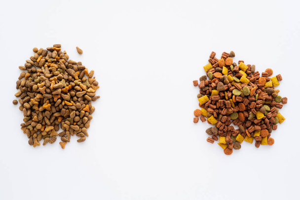 vista superior de diferentes alimentos secos para mascotas aisladas en blanco - Foto, imagen
