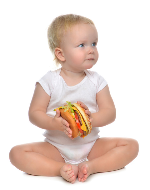 Fast food concept. Infant child baby toddler hold tasty unhealth - Photo, Image