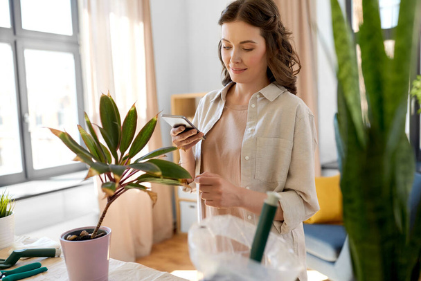 woman with smartphone and pot flower at home - Foto, Bild