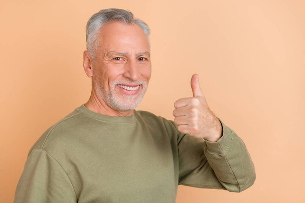 Photo of cheerful aged man show finger thumb-up approve good select isolated over beige color background - Foto, Bild