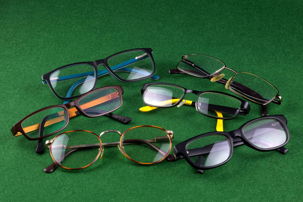 Gafas de ojos surtidos dispuestos en una superficie de fieltro verde - Foto, imagen