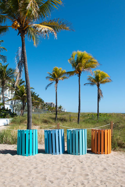 Разноцветные мусорные баки на пляже. - Фото, изображение