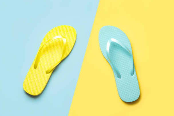 Summer holiday concept.Top view of colored beach flip flops over blue and yellow background - Photo, Image