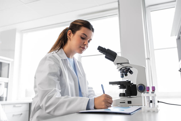 scientist with microscope working in laboratory - Photo, image