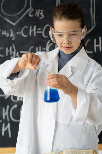 Schöne kleine Mädchen Wissenschaftler aufregen, um die Farbe Chemikalie im Labor durch die Verwendung von Kolben mit blauer Flüssigkeit zu untersuchen. Praxis und Bildung der Naturwissenschaften für Kinder unterstützen Konzept. Chemie-Experimente - Foto, Bild