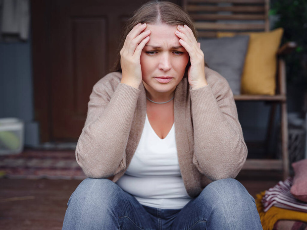 депрессивная женщина средних лет, сидящая на крыльце. - Фото, изображение