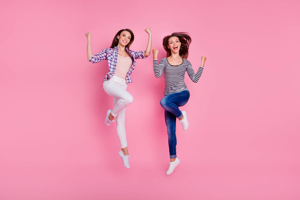 Full size photo of two sportive energetic people jumping raise fists isolated on pink color background - Фото, изображение