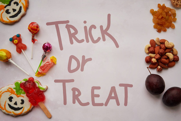 Truco o tratar el concepto de letras. Comida sana y poco saludable en comparación: Alternativa a los dulces y caramelos: nueces, frutas y frutas secas. Copiar espacio. Foto de alta calidad - Foto, imagen