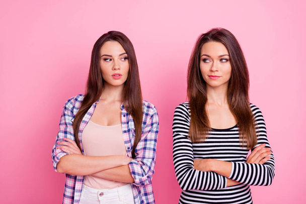 Portrait of two pretty unsatisfied girls crossed arms look each other isolated on pink color background - Photo, image