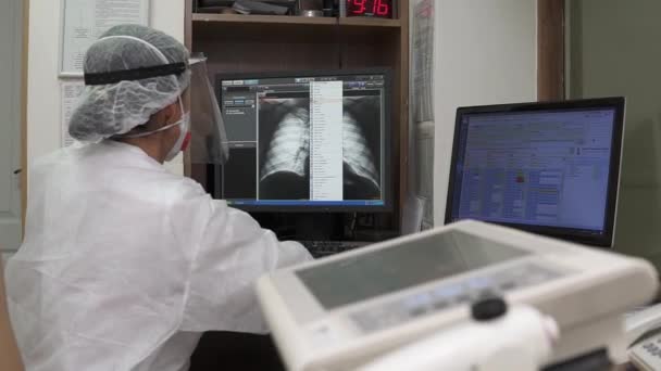 El médico mira la radiografía del tórax en la pantalla de la computadora en la oficina - Imágenes, Vídeo