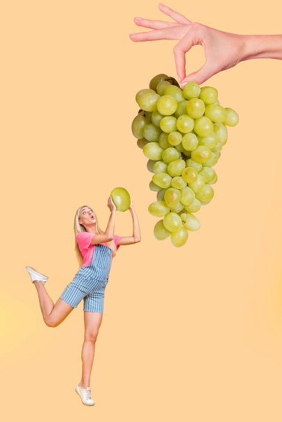 Vertical composite portrait of impressed person cut grape hanging huge hand isolated on beige color background - Foto, afbeelding