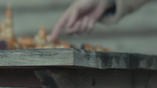Homem mão empurra peça de xadrez fora de mesa de madeira e quedas de peão - Filmagem, Vídeo