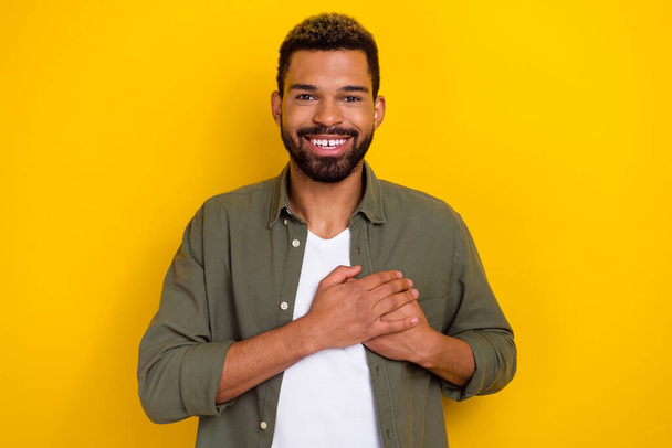Photo of dreamy handsome guy dressed green shirt arms chest smiling isolated yellow color background - Φωτογραφία, εικόνα