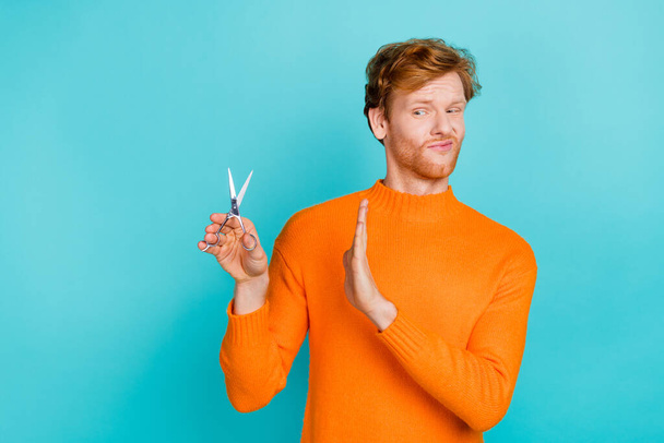 Photo of doubtful unsure guy dressed orange sweater dislike cutting hair isolated turquoise color background - Fotoğraf, Görsel