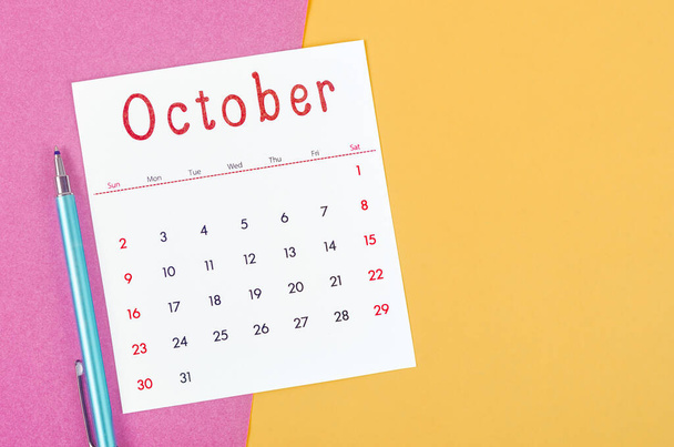 The October 2022 calendar  with pen on multicolored background. - Photo, Image