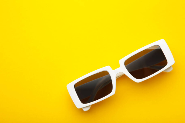 White sunglasses on yellow background, top view, flat lay, minimalistic concept of summer, vacation. Top view - Foto, Bild