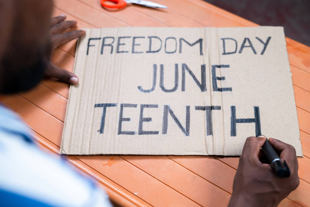 Снимок с плеча активиста, готовящего День свободы, июньская вывеска для марша - концепция независимости и кампании - Фото, изображение
