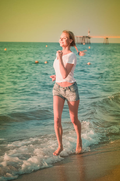 Sportswoman is jogging on the beach - Photo, image