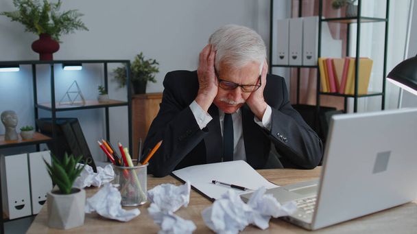 Senior business office man use laptop throwing crumpled paper, having nervous breakdown at work - Fotografie, Obrázek