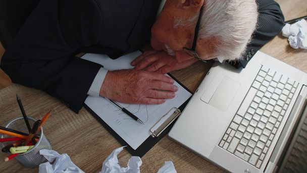 Cansado sonolento sobrecarregado homem de negócios idoso adormecido sentar-se em casa mesa de escritório com laptop - Foto, Imagem