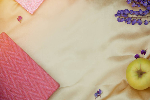 Altramuces flores púrpuras, cuaderno, decoraciones de manzana sobre fondo dorado. Concepto de invitación de verano, tarjeta de cumpleaños, Día de la madre. Lugar para el texto. Bienestar cercanía a la naturaleza, concepto de autodescubrimiento - Foto, imagen