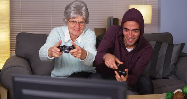 Літня жінка, грати відеоігри з іспаномовні людина - Фото, зображення