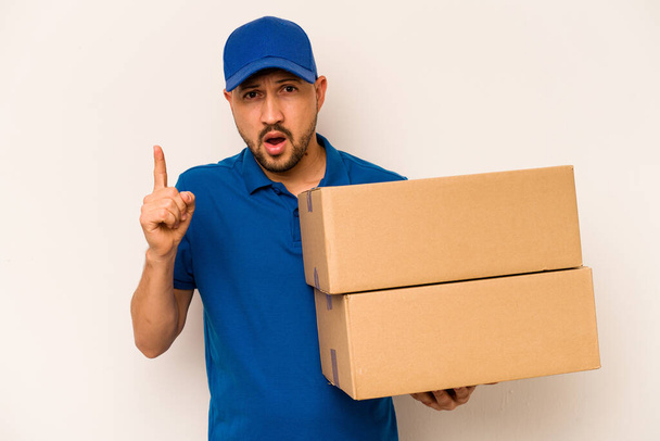 Hispanic delivery man isolated on white background having an idea, inspiration concept. - Photo, Image
