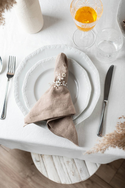 Table decor concept, linen white tablecloth and beige napkin, selective focus image - Fotó, kép