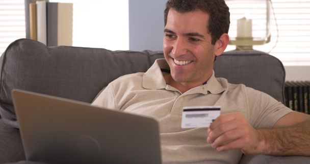 Uomo digitando le informazioni della carta di credito sul computer portatile
 - Foto, immagini