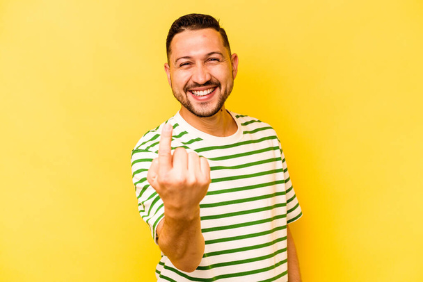 Молодий іспаномовний чоловік ізольований на жовтому тлі, вказуючи пальцем на вас, ніби запрошений наближається
. - Фото, зображення