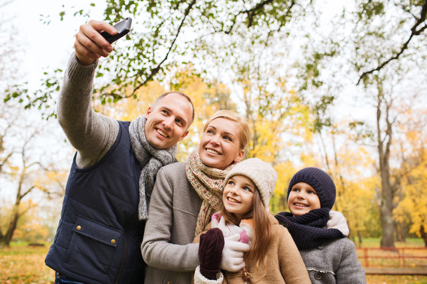 happy family with camera in autumn park - Foto, Imagem