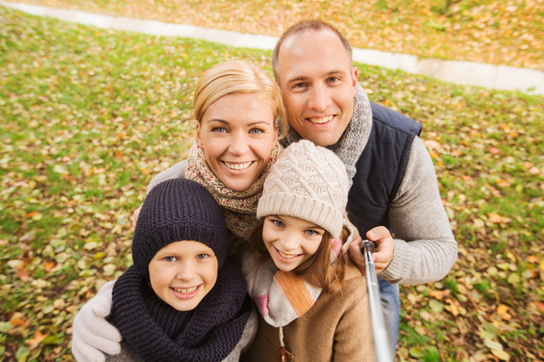 happy family with selfie stick in autumn park - Φωτογραφία, εικόνα