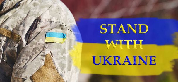Ukrán zászló másolási hely és szöveg Állj Ukrajna. Ukrán zászló katonai egyenruhán. Állítsa le az orosz agressziót. Állítsa meg a háborút Ukrajnában. Maradj Ukrajnával. Érzékelés. Imádkozz Ukrajnáért. - Fotó, kép