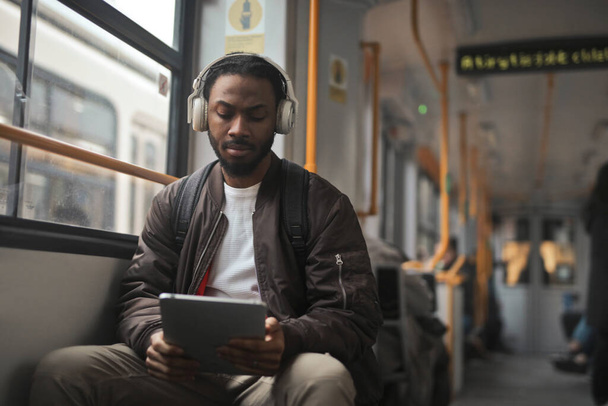 Portret młodego mężczyzny w tramwaju podczas korzystania z tabletu - Zdjęcie, obraz