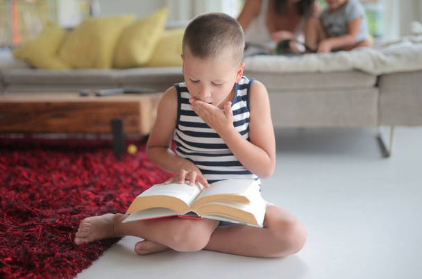 child reads a book in the house - Zdjęcie, obraz