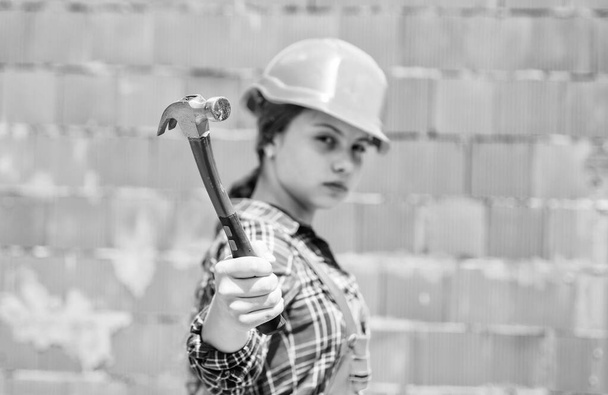 kid wear helmet on construction site. teen girl builder with building tool hammer. child on repairing work. concept of renovation in workshop. busy professional carpenter. Repair - Fotó, kép
