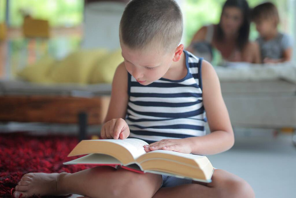 child reads a book at home - Fotó, kép
