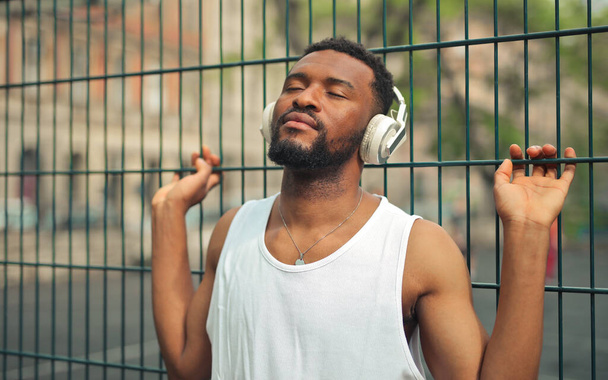 young man listens to the music with bluetooth headphones - Foto, Imagem