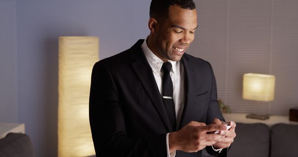 Bello uomo d'affari nero digitando su smartphone
 - Foto, immagini