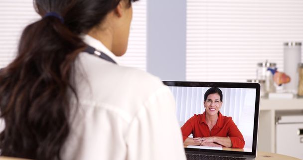 Hispanic doctor talking patient on laptop - Photo, Image