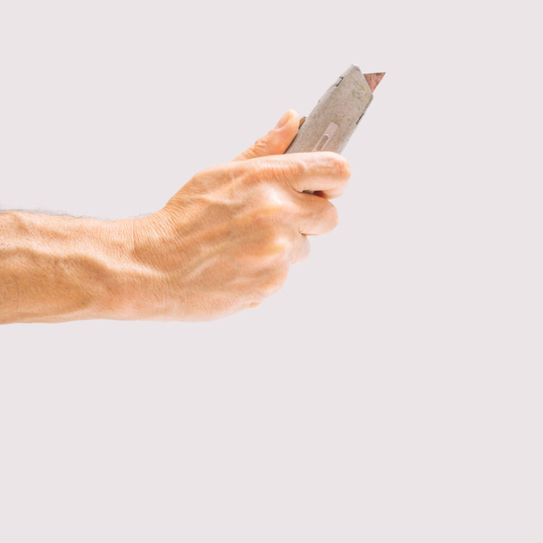 Die Hand des Mannes hält ein Maßband in Zoll und Zentimeter, um die Länge zu messen. Kunststoffbeschichtete Stahlklinge. Messung der Hände, grüner Hintergrund - Foto, Bild