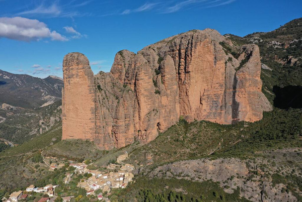 Panoramatický pohled na slavné skalní útvary Mallos de Riglos ve Španělsku pod světle modrým pozadím - Fotografie, Obrázek