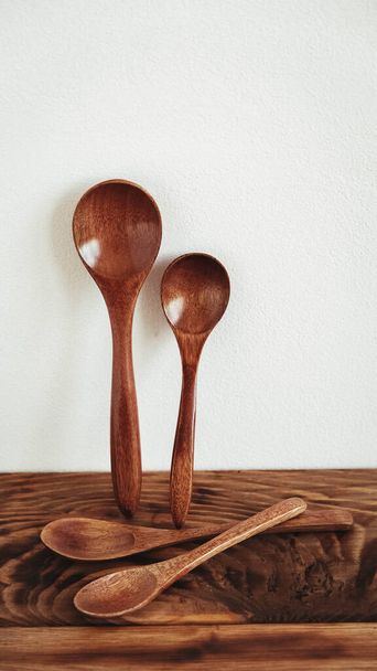 Wooden spoons from dark wood on a wooden table background. - Foto, Bild