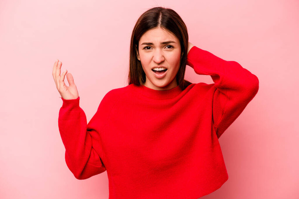 Young caucasian woman isolated on pink background screaming with rage. - Foto, imagen
